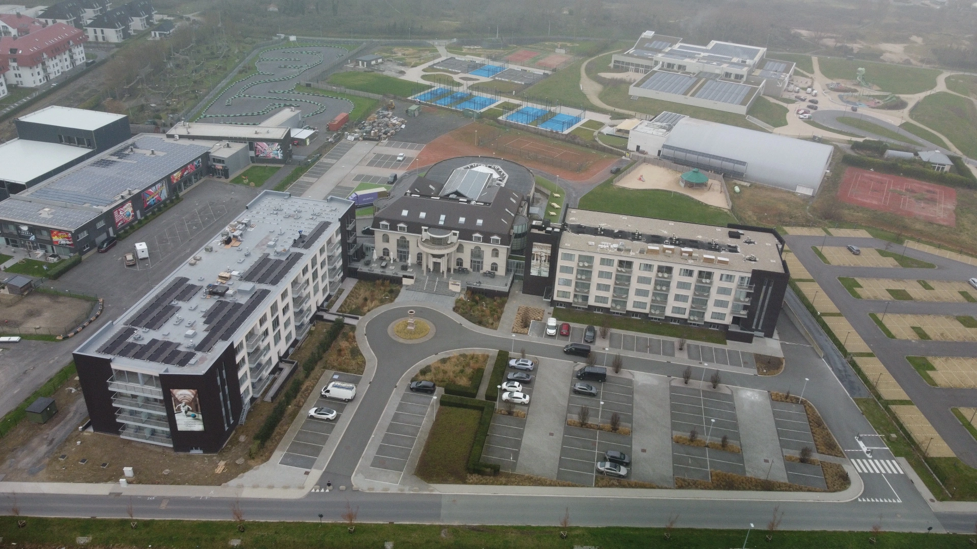 Drone foto zonnepanelen Hotel Acropolis Middelkerke - 470 panelen oost-west opstelling op plat dak met laadinfrastructuur Solarnation