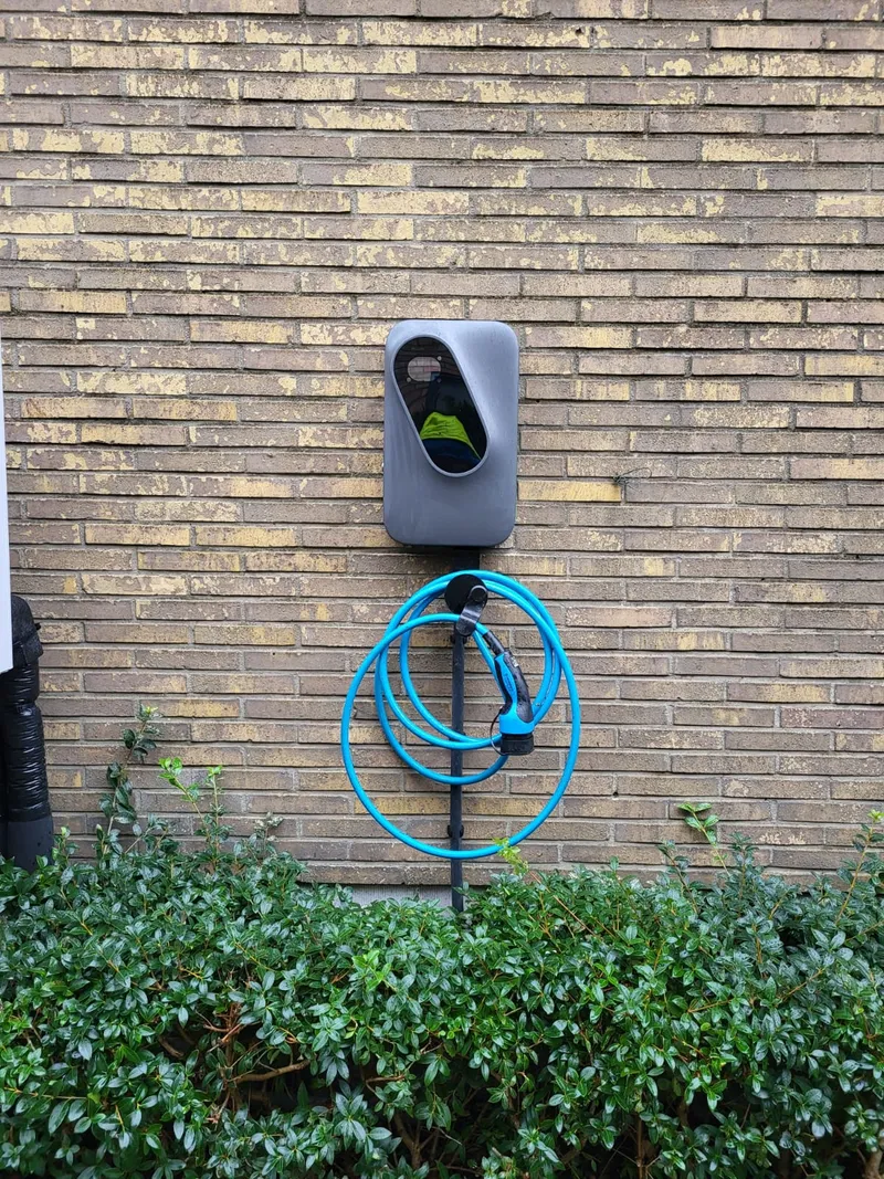 Etrel INCH Pro Socket laadpaal in antraciet gemonteerd op bakstenen muur met type 2 laadkabel