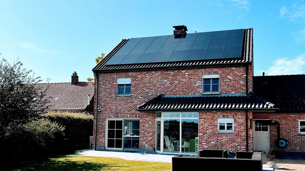 Sonnex 475Wp Back Contact full black zonnepanelen op een Belgische woning — strak zwart design op bakstenen huis